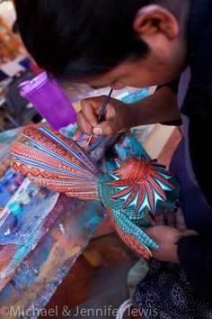 a woman is working on an art project with acrylic paint and paper machils