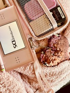 the contents of an electronic device are laid out on a white blanket with pink sequins