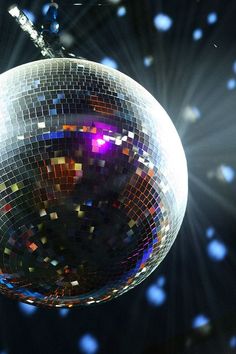 a disco ball hanging from the ceiling in front of bright lights