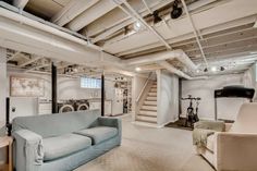 a living room filled with furniture next to a staircase