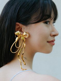 Inspired by the iconic form of its namesake, the Asymmetric Bow Earrings are a modern take on the classic shape and reimagined in the form of a stunningly statement mismatched pair of earrings - including one Bow XL Earring and one Mini Bow Stud. Immortalised as a handcrafted piece and plated in a choice of 22k Gold or Silver Rhodium, MISHO reinvents the ribbon with sculptural twist. Mismatch Earrings, Mini Bow, Bow Jewelry, Mismatched Earrings, Mini Bows, India Jewelry, Bow Earrings, 22k Gold, How To Make Bows