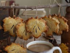 some dried leaves hanging from a rope next to a cup of coffee