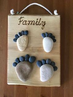 a wooden plaque with three rocks and the words family on it