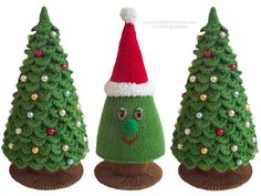 three knitted christmas trees with santa's hat on top, one green and the other red