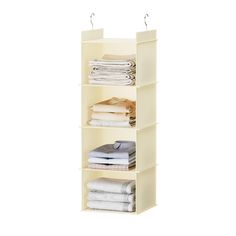 an open shelf with folded clothes and folded towels on it, against a white background