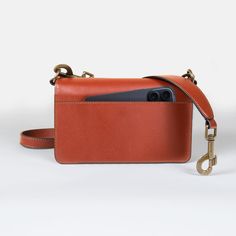 In pursuit of perfection the Denby - Italian Leather Cognac Saddle Bag, where classic equestrian charm meets modern sophistication. Inspired by English riding traditions, this petite saddle bag features a sleek flat bottom and distinctive brass stirrup hardware. It includes dual straps, a stylish lunch pail handle, and an adjustable shoulder strap for versatile carrying options. Inside, you'll find thoughtfully designed pockets, zipper pouches, and a convenient cell phone sleeve on the back. The Brown Flap Bag With Metal Hardware For Work, Rectangular Shoulder Bag With Horsebit Detail For Everyday Use, Rectangular Bags With Horsebit Detail For Everyday Use, Travel Satchel Shoulder Bag With Horsebit Detail, Travel Shoulder Bag With Horsebit Detail Satchel, Classic Saddle Bag Satchel With Metal Hardware, Timeless Brown Saddle Bag With Gold-tone Hardware, Classic Satchel Saddle Bag With Metal Hardware, Classic Brown Shoulder Bag With Horsebit Detail