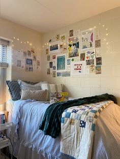 a bedroom with white walls and pictures on the wall above the bed, along with lights