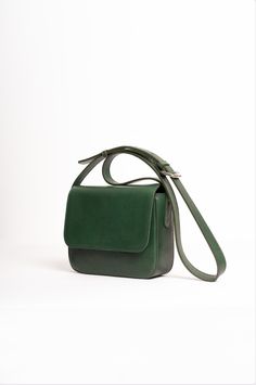 Natural-grained leather fanny pack lined with cotton fabric a metal zipper closure, and an adjustable strap allowing it to be worn over the shoulder as a crossbody bag, or around the waist. It has two zippered pockets, one on the front and one on the back. Classic Saddle Bag With Adjustable Strap For On-the-go, Daily Use Double Flap Bag With Removable Pouch, Daily Use Bag With Removable Pouch And Double Flap, Modern Double Flap Bags For Travel, Elegant Green Bag With Double Flap, Classic Shoulder Flap Bag With Adjustable Strap, Elegant Green Double Flap Bag, Luxury Green Double Flap Bag, Green Leather Double Flap Bag