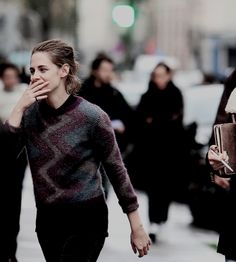 a woman walking down the street while talking on her cell phone