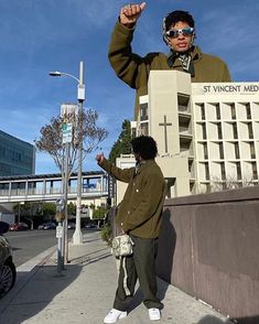 two people standing next to each other in front of a building with a cross on it