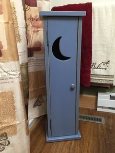 a blue cabinet sitting on top of a hard wood floor next to a shower curtain