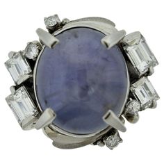 A dazzling mid-century ring, circa 1960’s. It features a 9.35 carat star sapphire with excellent transparency, your eyes will get lost inside the stone. Accenting the sapphire are 4 large chunky baguette-cut diamonds along with 4 round brilliants, totaling 0.70 carats. Hand-fabricated in platinum, this bold ring is a keeper. Ring Size 5.25 Bold Rings, Platinum Diamond Rings, Star Sapphire, Baguette Cut Diamond, Star Ring, Platinum Ring, Sapphire Diamond, Cocktail Rings, Round Brilliant