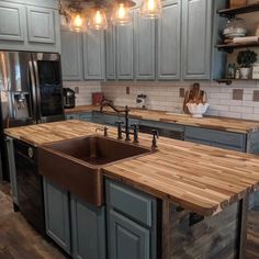 a kitchen with wooden counter tops and gray cabinets