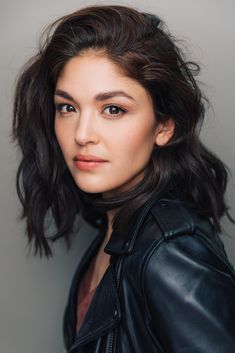 a woman in a leather jacket posing for a photo