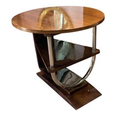 a wooden table with metal legs and a circular glass shelf on one end, against a white background