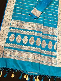 SILK MARK CERTIFIED !!Gorgeous Pure Katan Turquoise Color with undertone of Blue with Copper and Slier Zari Work. Strips Sarees in Copper and Sliver Zari with Floral Buttas on the Pallu Soft, light weight and easy to drape Saree. The Strips are dense towards the pallu and get scattered the other end. Item : SareeColor : Turquoise Color with undertone of BlueBase Fabric : Pure Katan Silk Blouse piece : Comes with Blouse pieceBlouse material : Pure Katan SilkFall & Edging (Yes/No) : YesComes with Turquoise Festive Blouse Piece With Traditional Drape, Festive Turquoise Saree With Dupatta, Festive Turquoise Blouse Piece With Traditional Drape, Festive Turquoise Blouse Piece, Eid Turquoise Art Silk Traditional Wear, Turquoise Zari Weaving Saree, Unstitched Turquoise Saree With Zari Work, Festive Turquoise Banarasi Silk Saree, Festive Banarasi Silk Saree In Turquoise