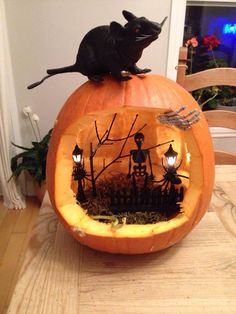 a mouse sitting on top of a carved pumpkin