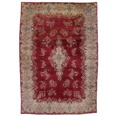 an antique persian rug with red and gold colors on the center, surrounded by floral designs