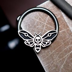 IMPORTANT (size & measuring guide): https://metallotus.com/blogs/body-jewelry/how-to-measure-your-piercingHandmade one at a time out of niobium and tarnish-resistant sterling silver - completely nickel free. This 16 gauge death moth captive bead ring works well for septum, daith, conch and helix piercings.The hoop is made out of pure, unalloyed niobium, and the captive bead is made out of Argentium silver that has been carefully antiqued then given a hand-brushed finish to highlight the blac Funny Septum Jewelry, Cool Septum Jewelry, Moth Ring, Cute Septum Rings, Daith Piercings, Captive Bead Ring, Conch Piercings, Septum Piercing Jewelry, Helix Piercings