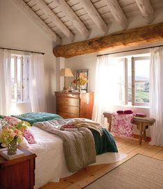 a bed room with a neatly made bed next to two windows and a wooden dresser