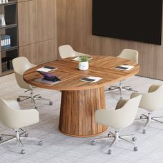 a round wooden table with white chairs around it in an office setting on the floor