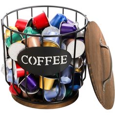 a metal basket filled with lots of different types of coffee beans and cups next to a wooden lid