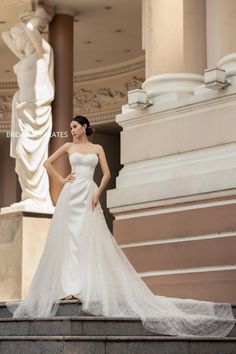 a woman in a wedding dress standing on some steps