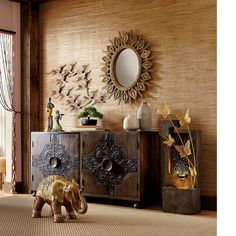 an elephant statue in front of a wooden cabinet