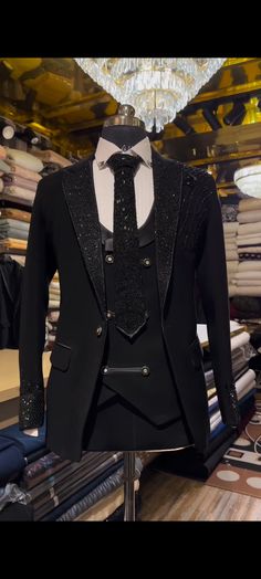 a suit and tie on display in a clothing store, with other items behind it