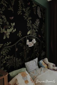 a bedroom with a bed, teddy bear and wallpaper on the walls behind it