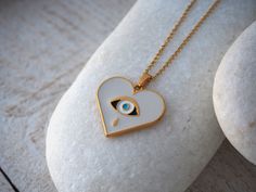 Material and Size -Size of heart is 25,4 mm X 22,6 mm -Material :Gold plated 24 k Pewter with high quality white enamel which decorated with a colored ethnic evil eye -Pewter is very durable and is not tarnish easily If you follow care instructions also is lead and nickel free and is not causes allergic reactions Size of chain :This chain is made from stainless steel and comes in three lengths 40 cm, 45 cm, 50 cm with 3 cm extension each one for perfect fit. Model is wearing 45 cm and you have c White Hypoallergenic Heart-shaped Jewelry, White Stainless Steel Jewelry For Gifts, White Stainless Steel Jewelry For Gift, White Stainless Steel Jewelry Gift, Personalized White Stainless Steel Charm Necklace, White Heart-shaped Hypoallergenic Necklace, White Heart-shaped Minimalist Jewelry, Minimalist White Heart-shaped Jewelry, Hypoallergenic White Heart Necklace