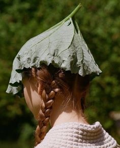 a woman with a green leaf on top of her head