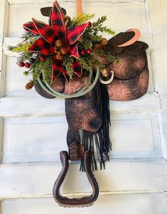 a horse head hanging on the side of a door with flowers and decorations attached to it