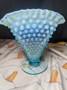 a blue glass vase sitting on top of a table