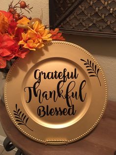 a gold plate with the words grateful, thank and blessed on it next to flowers