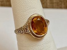 Welcome To Gold Knox Beautiful Art Deco 14k white gold ring featuring a genuine oval faceted citrine securely set in bezel on a filigree designed ring setting. This beautiful piece of jewelry featuring November's birthstone, would be a great gift for any occasion. Details Below: Material 14K white gold, yellow citrine Size 6 US Stone 8mm X 7mm (approximate 1.25 ct) Hallmark 14k This would make great addition to your vintage collection. Thank you for looking Gold Knox opened its storefront in Pas Oval Yellow Gold Filigree Ring With Gemstone, Oval Gemstone Filigree Ring In Art Deco Style, Formal Oval Topaz Ring With Filigree, Formal Oval Solitaire Filigree Ring, Oval Solitaire Filigree Ring For Formal Occasions, Oval 14k Gold Filigree Ring, Oval Diamond Cut Filigree Ring, Gold Diamond Drop Earrings, Light Blue Gemstone