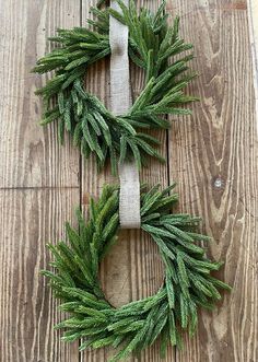 two wreaths made out of branches on top of a wooden floor