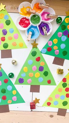 christmas tree craft made with construction paper and colored glue on a table top, surrounded by other crafts