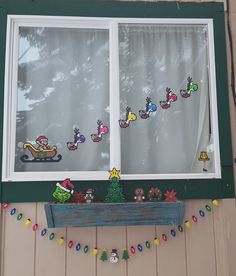 a window decorated with christmas decorations and santa's sleighs