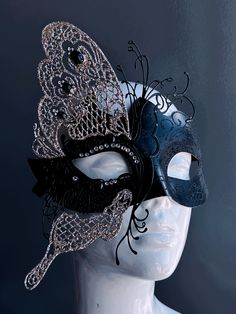 This glittering mask takes on the shape of a butterfly, symbolizing transformation and grace. The striking contrast of black and silver exudes an air of opulence and charm, while shimmering rhinestones adorn the mask. Whether you're attending a grand masquerade ball or a themed gala this mask ensures you'll be the center of attention. Age Group/Gender - Adult/Women Size/Type - One size fits all adults Mask Color - Black/Silver Mask Material - Polyresin and laser cut metal Masquerade Mask With Glasses, Elegant Silver Eye Mask, Elegant Black Masks And Prosthetics For Party, Elegant Black Masks And Prosthetics For Theater, Elegant Black Party Masks And Prosthetics, Elegant Black Eye Mask For Masquerade, Elegant Black Mask For Costume Party, Elegant Black Eye Mask, Black Eye Mask For Evening Masquerade