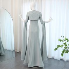 Fangen Sie die Essenz der Eleganz mit unserem verträumten, salbeigrünen Meerjungfrauen-Abendkleid ein. Mit luxuriöser Perlenverzierung und Cape-Ärmeln strahlt dieses Kleid Raffinesse aus. Perfekt für Hochzeiten und formelle Anlässe – setzen Sie mit diesem atemberaubenden Stück ein Statement. Fitted Evening Dress With Cape Sleeves For Wedding, Wedding Evening Dress With Cape Sleeves, Wedding Evening Dress With Fitted Bodice And Cape Sleeves, Fitted Embellished Evening Dress With Cape Sleeves, Fitted Cape Sleeve Wedding Dress, Fitted Cape Sleeve Dress For Mother Of The Bride, Evening Dress With Cape, Dress With Cape Sleeves, Quinceanera Dresses Red