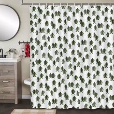 a bathroom with a white shower curtain and green christmas trees on the shower curtain is shown