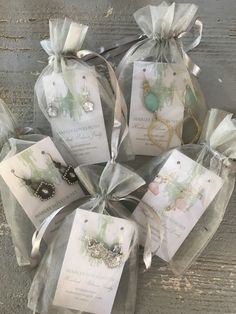 six bags filled with jewelry sitting on top of a wooden table