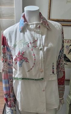 a mannequin wearing a white jacket with colorful flowers on it's chest