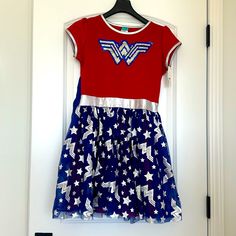 a red, white and blue dress hanging on a door frame with the wonder woman logo