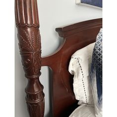 the headboard and foot board of a wooden bed with white linens on it