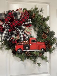 a christmas wreath with a red truck and pine cones