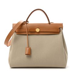 This is an authentic HERMES Military Toile Vache Hunter Herbag Zip Retourne 31 PM in Beton and Naturel. This stylish large tote is crafted of sturdy beige toile canvas and features a light brown leather top crest with a leather top handle, shoulder strap and a rear exterior zipper pocket. The front flap opens with double straps with gold hardware and a padlock. This opens to a matching canvas interior and includes a removable pouch. Luxury Ralph Lauren Shoulder Bag With Gold-tone Hardware, Herbag Hermes, Hermes Purse, Brown Leather Top, Earbud Case, Dream Bags, Light Brown Leather, Hermes Bags, Hermes Bag