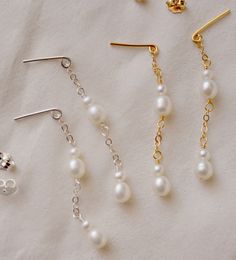 A whisper of pearls. These delicate droplet earrings are handcrafted with natural white freshwater pearls suspended from a shimmering chain of sterling silver or 14k gold filled. Elegant and timeless, these earrings will grace any special occasion, wedding, or everyday look. EARRING LENGTH: 1.5" (38mm) White Long Drop Pearl Earrings In 14k Gold Filled, White Long Drop Pearl Earrings In 14k Gold, Gold Sterling Silver Pearl Chain Earrings, Elegant Silver Pearl Earrings With 14k Gold Filled, Dainty Sterling Silver Pearl Chain Earrings, Teardrop Pearl Chain Earrings For Anniversary, Silver Drop Pearl Earrings In 14k Gold Filled, Silver Pearl Earrings With 14k Gold Filled Ear Wire, Silver Drop Pearl Earrings With 14k Gold Filling