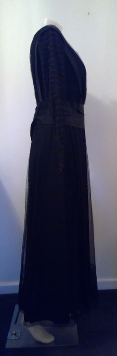 "A most amazing dress ! Edwardian mourning gown. Black silk underneath with top layer of black dotted mesh and trim pieces. Bodice interior is muslin with boning. Closes up in the back with hook and eyes, snaps on the skirt layers. Sash that hangs down the front and back with dangling acorns, one acorn needs repair. Alot if not all of this dress is hand sewn. Sleeves are amazing ! Double layer of mesh. Top layer is sewn in tiers with little satin covered buttons all the way down, decorative, the Elegant Floor-length Victorian Dress For Theater, Victorian Dress With Lace Trim For Evening, Victorian Evening Dress With Lace Trim, Regency Style Black Evening Dress, Black Regency Style Evening Dress, Black Gothic Victorian Dress For Evening, Black Victorian Dress With Lace Trim For Evening, Victorian Black Dress For Theater, Victorian Black Party Dress